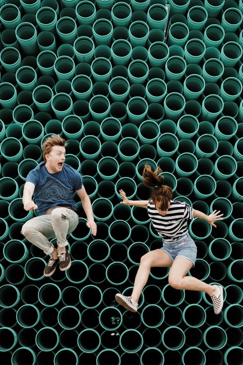 Deux jeunes adultes sautant sur un fond graphique composé de tubes verts, incarnant l’énergie, la créativité et l’audace collective dans l’univers Calidius.